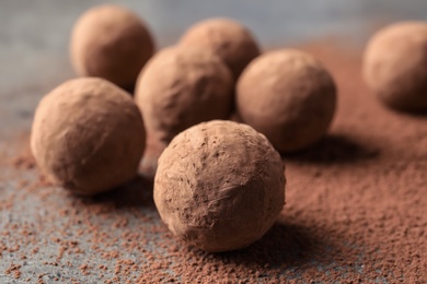 Delicious raw chocolate truffles on grey background