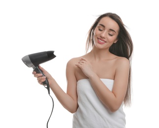 Beautiful young woman using hair dryer on white background