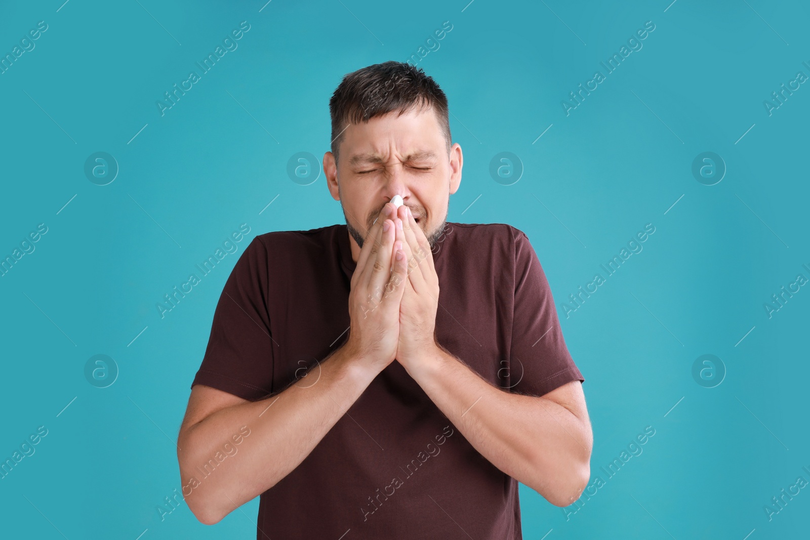 Photo of Man suffering from allergy on blue background