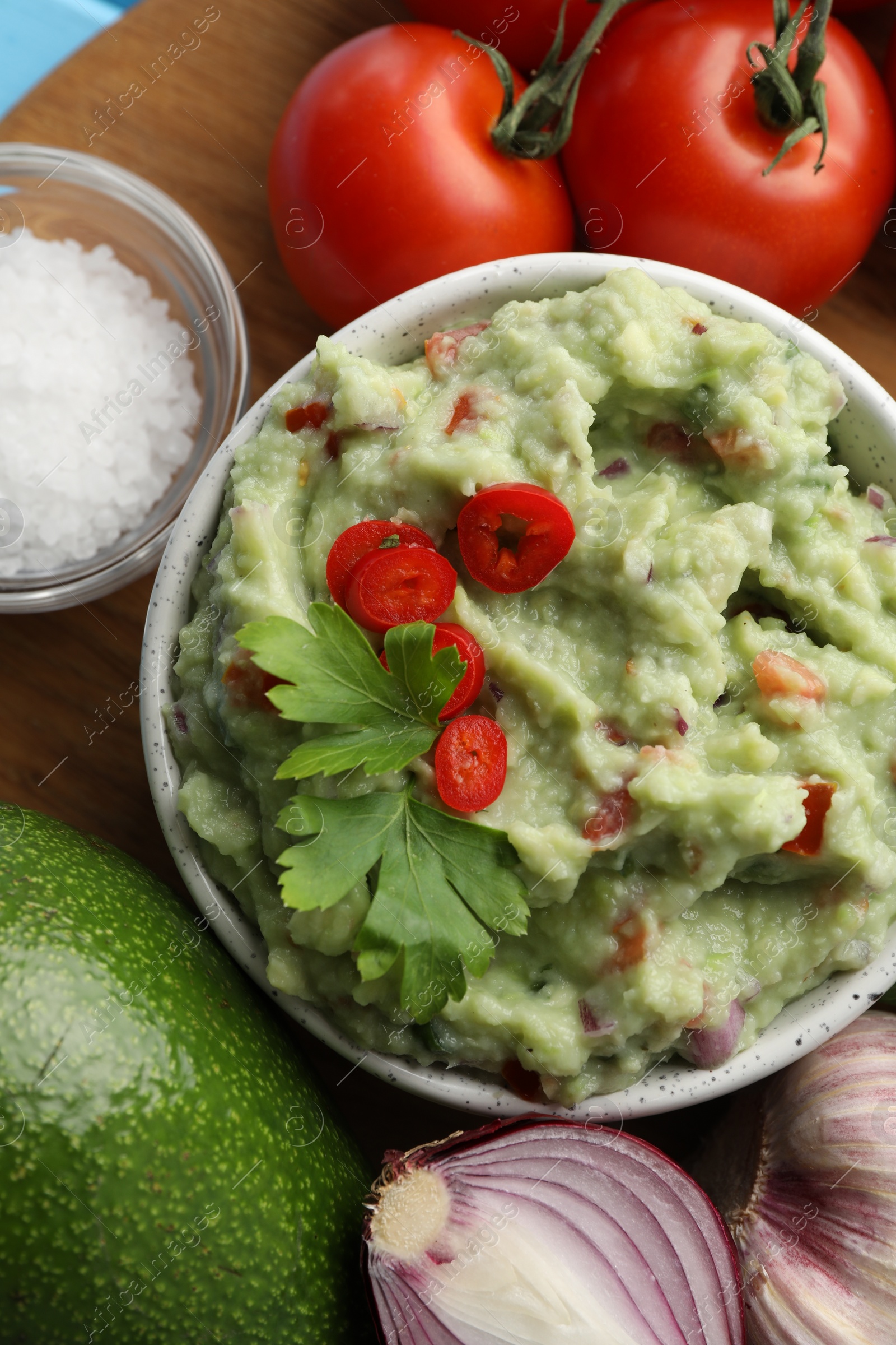 Photo of Delicious guacamole and ingredients on table, flat lay