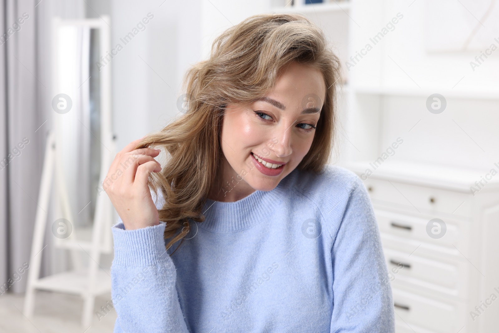 Photo of Portrait of smiling woman with curly hair at home