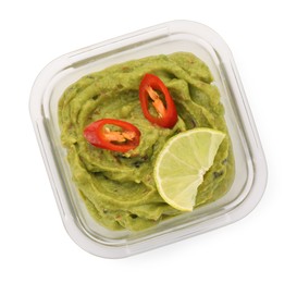 Photo of Bowl of delicious guacamole with chili pepper and lime isolated on white, top view