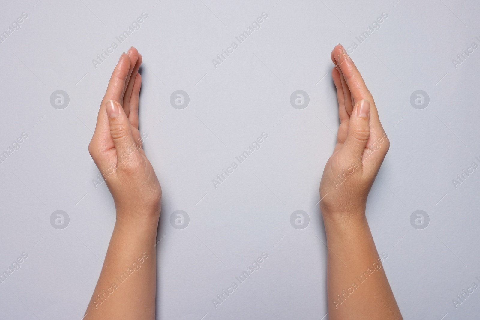 Photo of Woman holding on light grey background, closeup of hands. Space for text