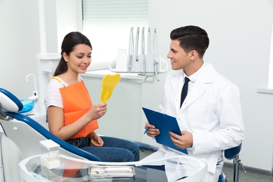 Photo of Professional dentist working with patient in clinic