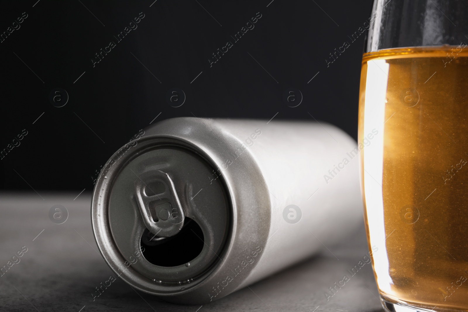 Photo of Energy drink in glass and aluminium can on grey table, closeup