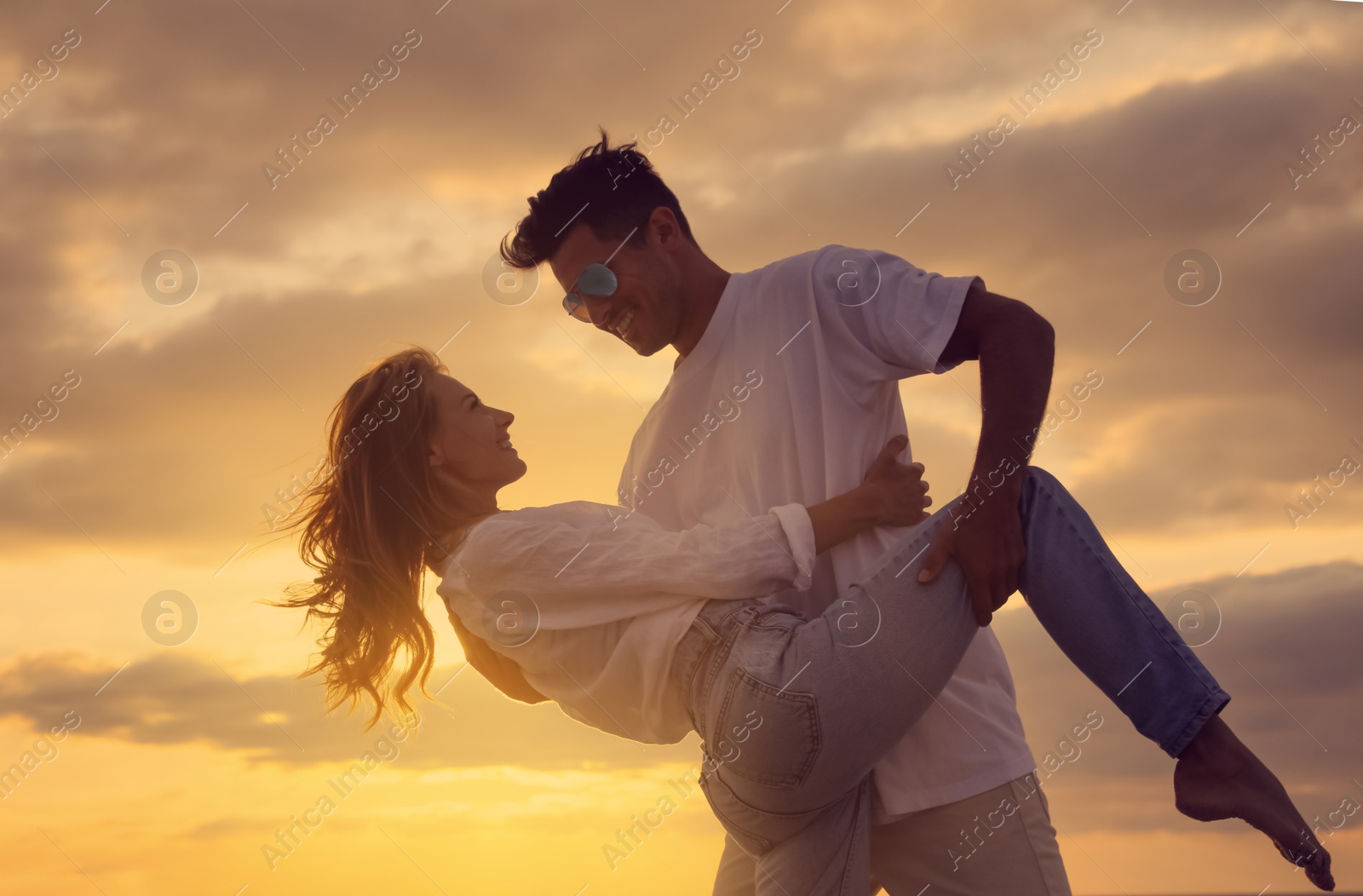 Photo of Happy couple dancing on beach at sunset