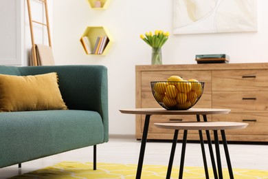 Photo of Spring interior. Bowl of lemons on wooden table in living room, space for text