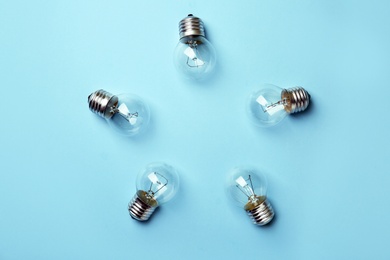 New incandescent lamp bulbs on light blue background, top view