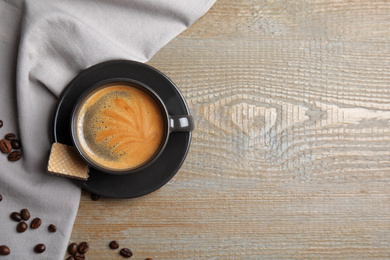 Photo of Breakfast with delicious wafer and coffee on wooden table, flat lay. Space for text