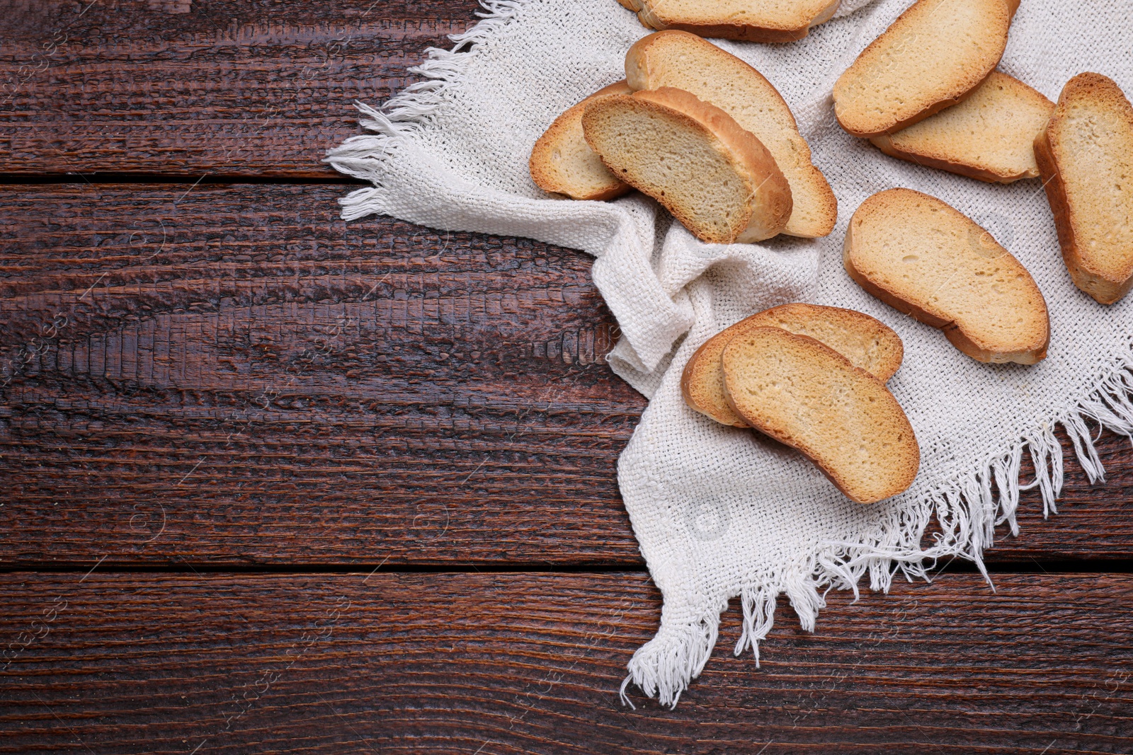 Photo of Tasty hard chuck crackers on wooden table, flat lay. Space for text