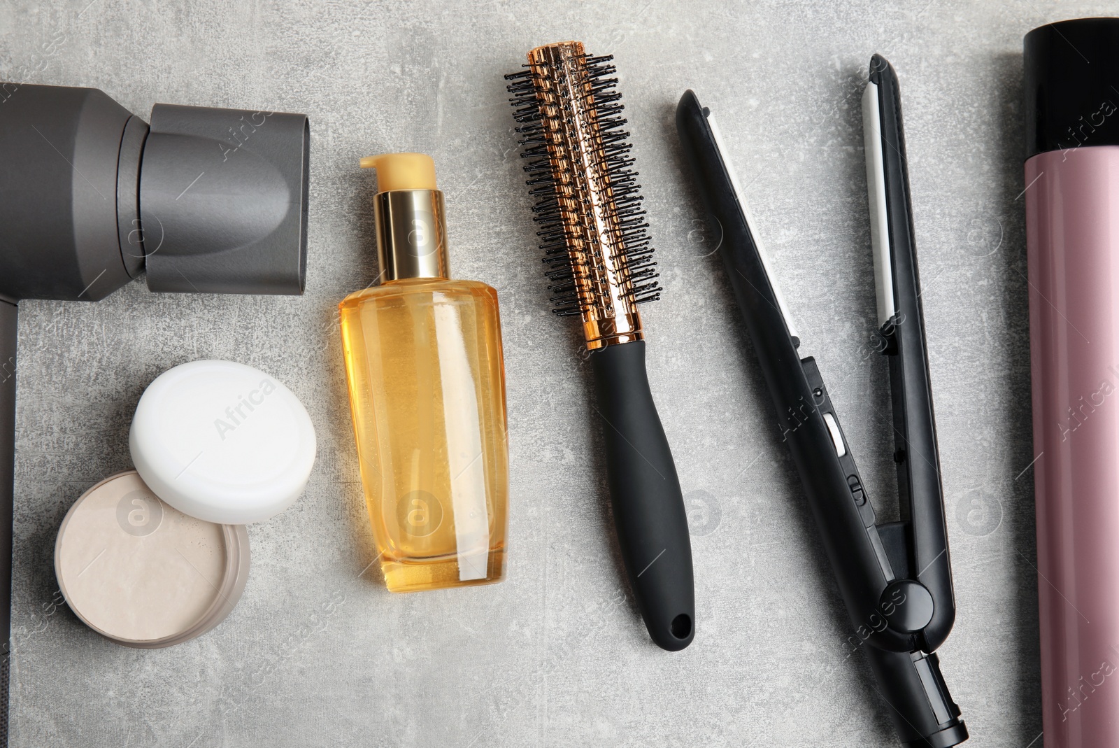 Photo of Flat lay composition with hairdressing equipment on grey stone background