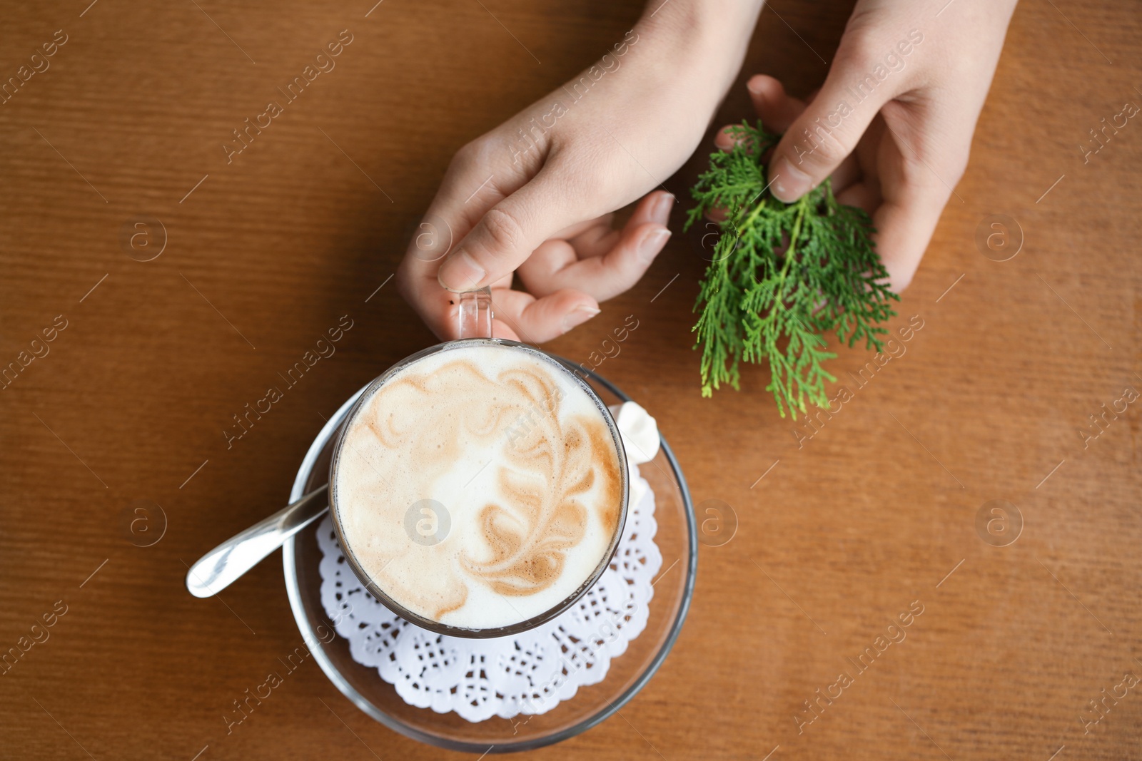 Photo of Woman with cup of aromatic coffee on wooden background, top view