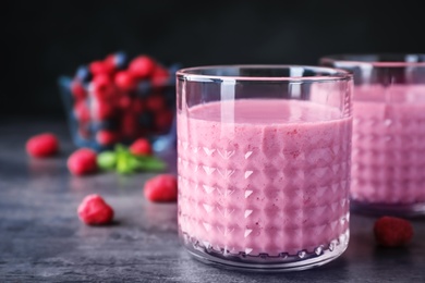 Photo of Delicious smoothie in glasses and fresh raspberries on table