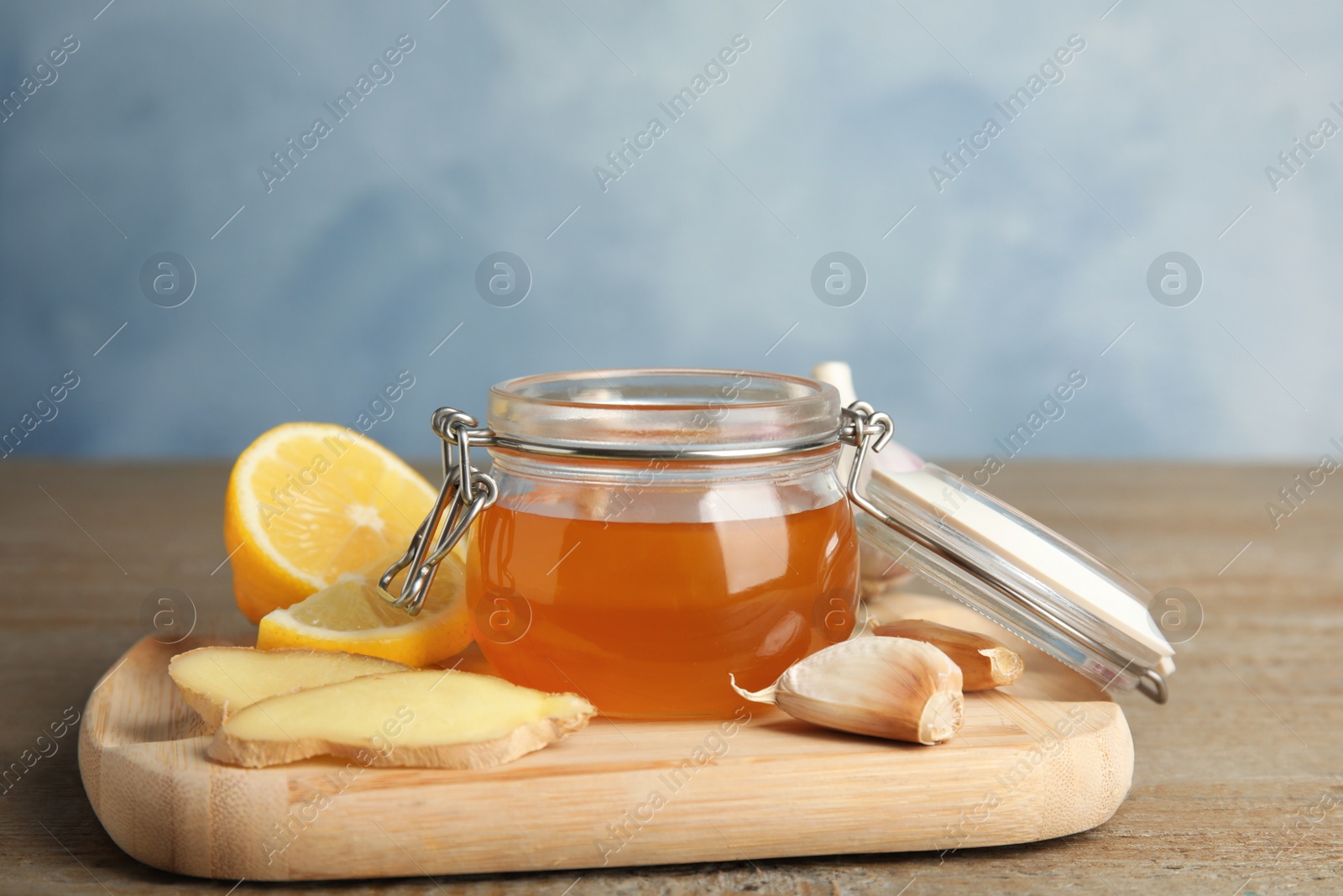 Photo of Cold remedies on wooden table against blue background. Sore throat treatment