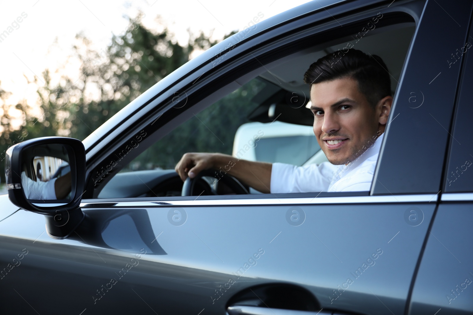 Photo of Handsome man in his modern car, view from outside