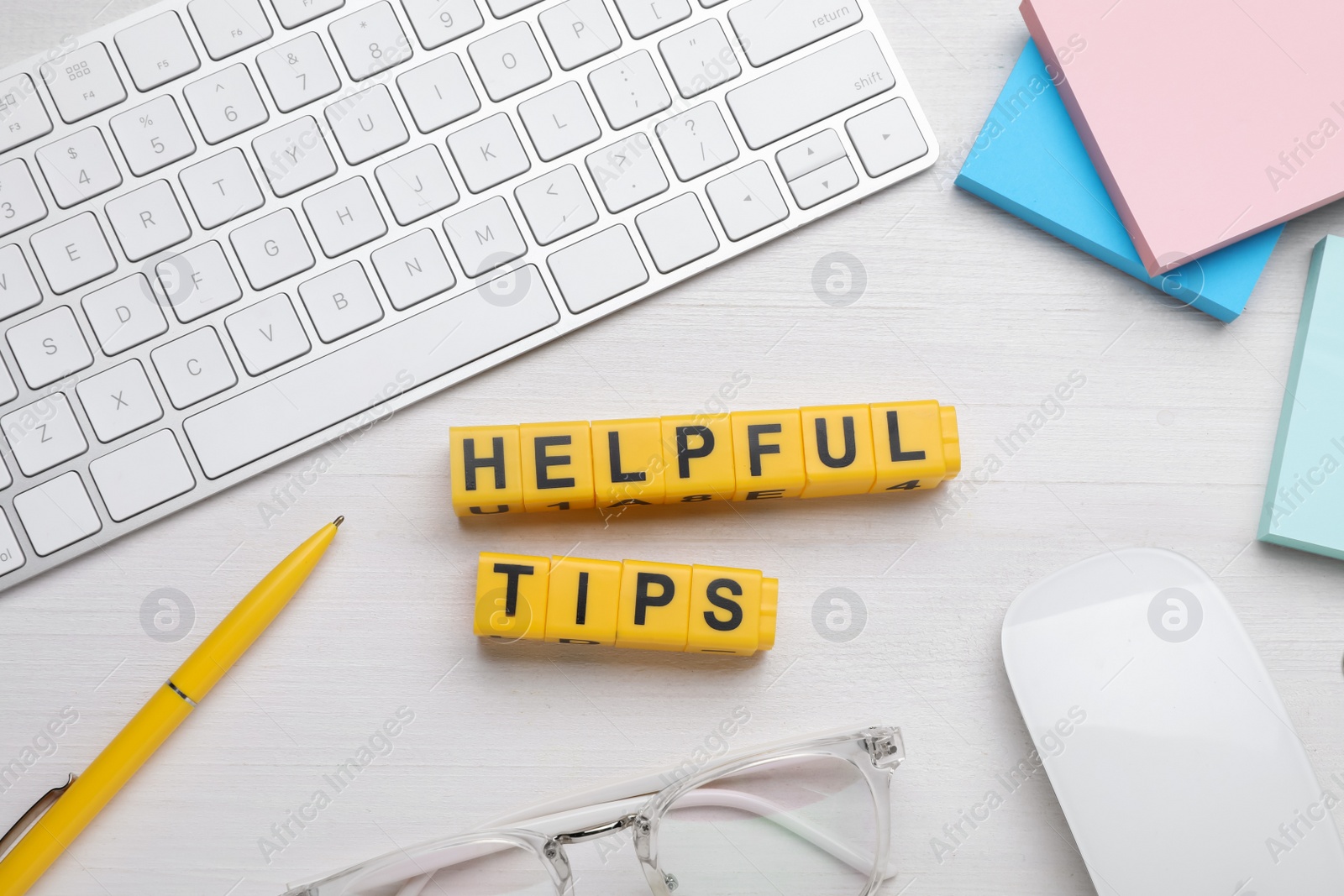 Photo of Flat lay composition with phrase Helpful Tips made of yellow cubes on white wooden table