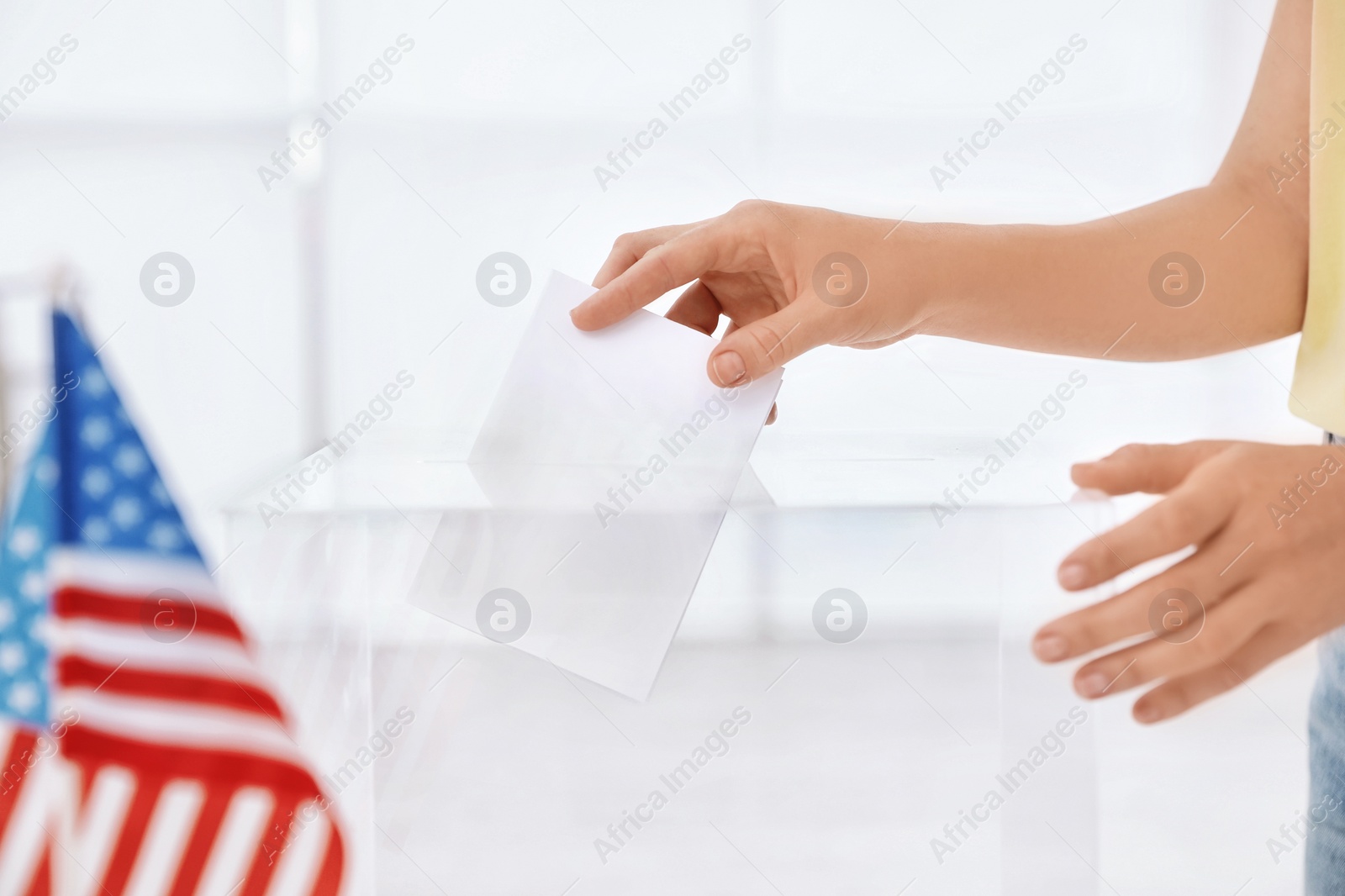 Photo of Woman putting ballot paper into box at polling station, closeup