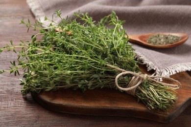 Bunch of aromatic thyme on wooden table, closeup