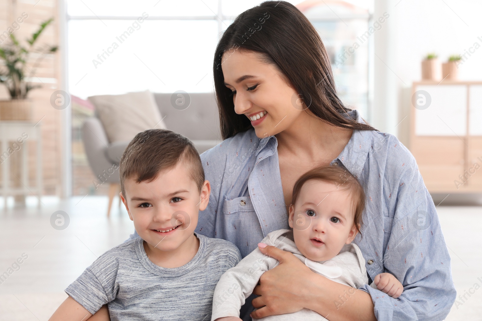 Photo of Happy mother with her cute children at home. Family time
