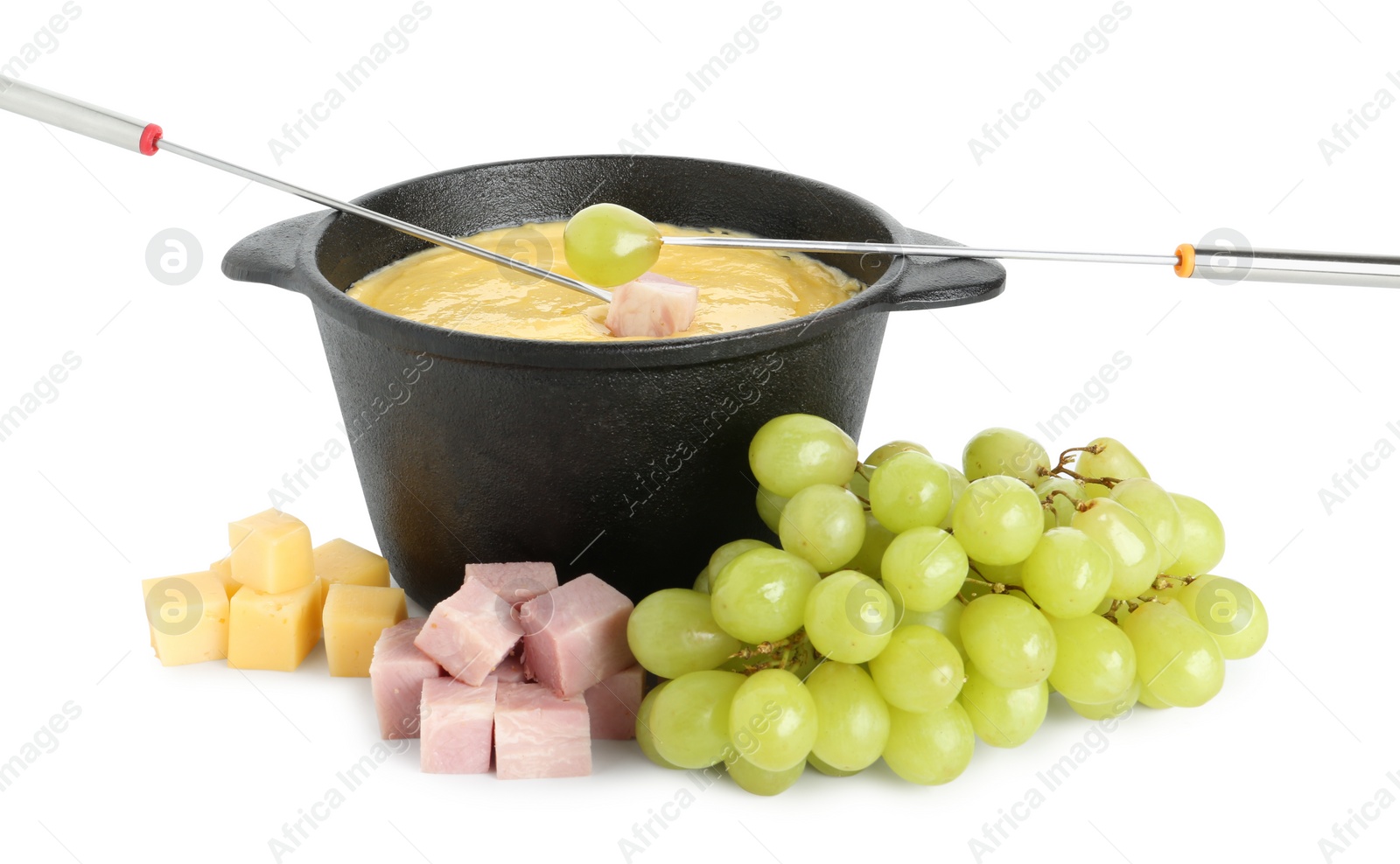Photo of Dipping grape and ham into fondue pot with tasty melted cheese isolated on white