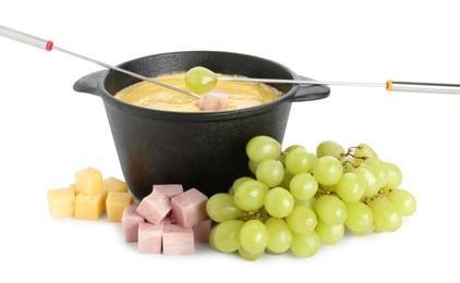 Photo of Dipping grape and ham into fondue pot with tasty melted cheese isolated on white