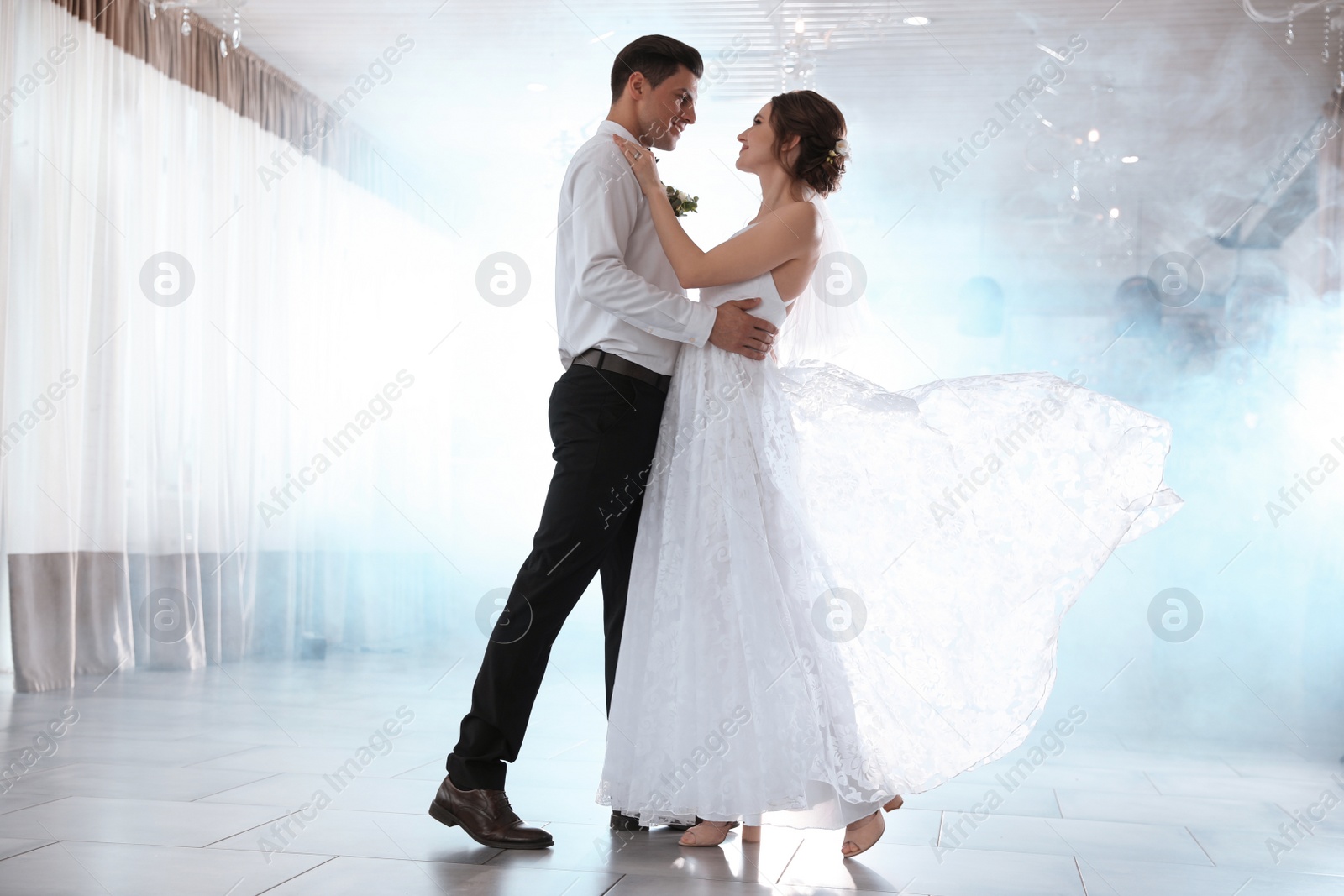 Photo of Happy newlywed couple dancing together in festive hall