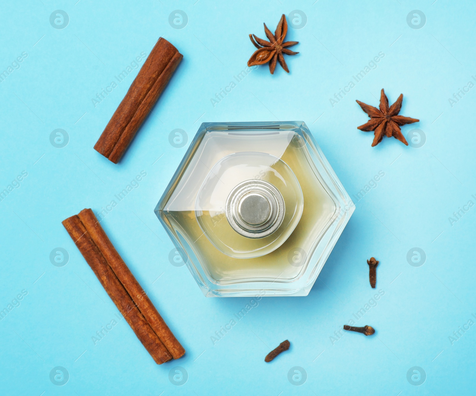 Photo of Bottle of perfume and spices on color background, top view