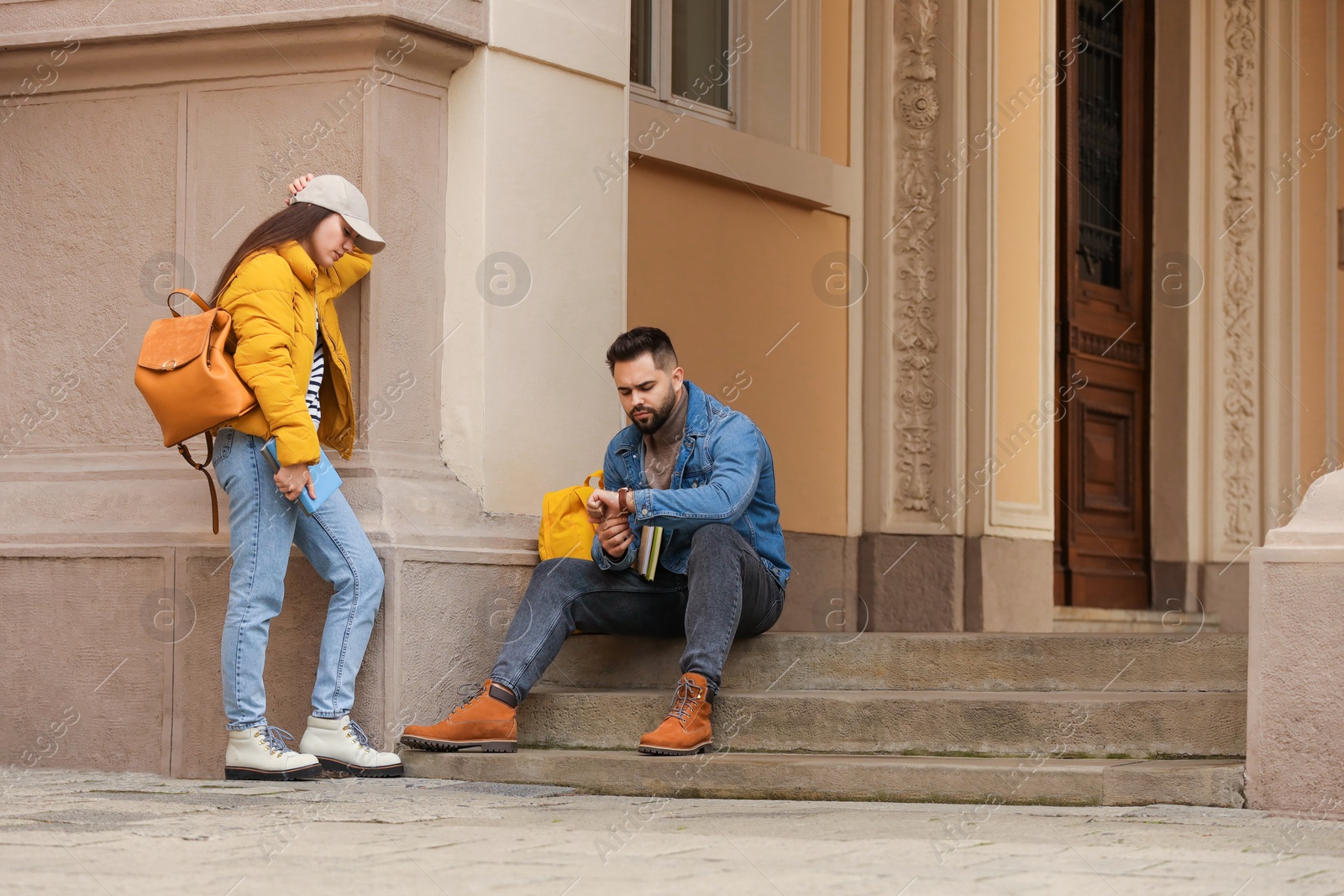 Photo of Being late. Worried students near building outdoors, space for text