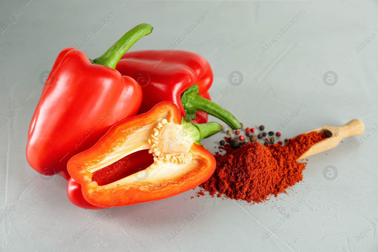 Photo of Fresh bell peppers and scoop of paprika powder on white table