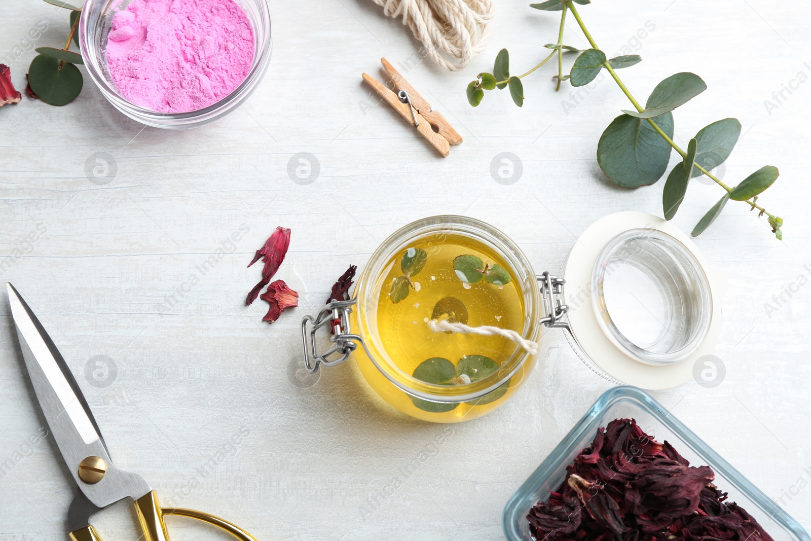 Photo of Flat lay composition with homemade candle in glass jar on light table