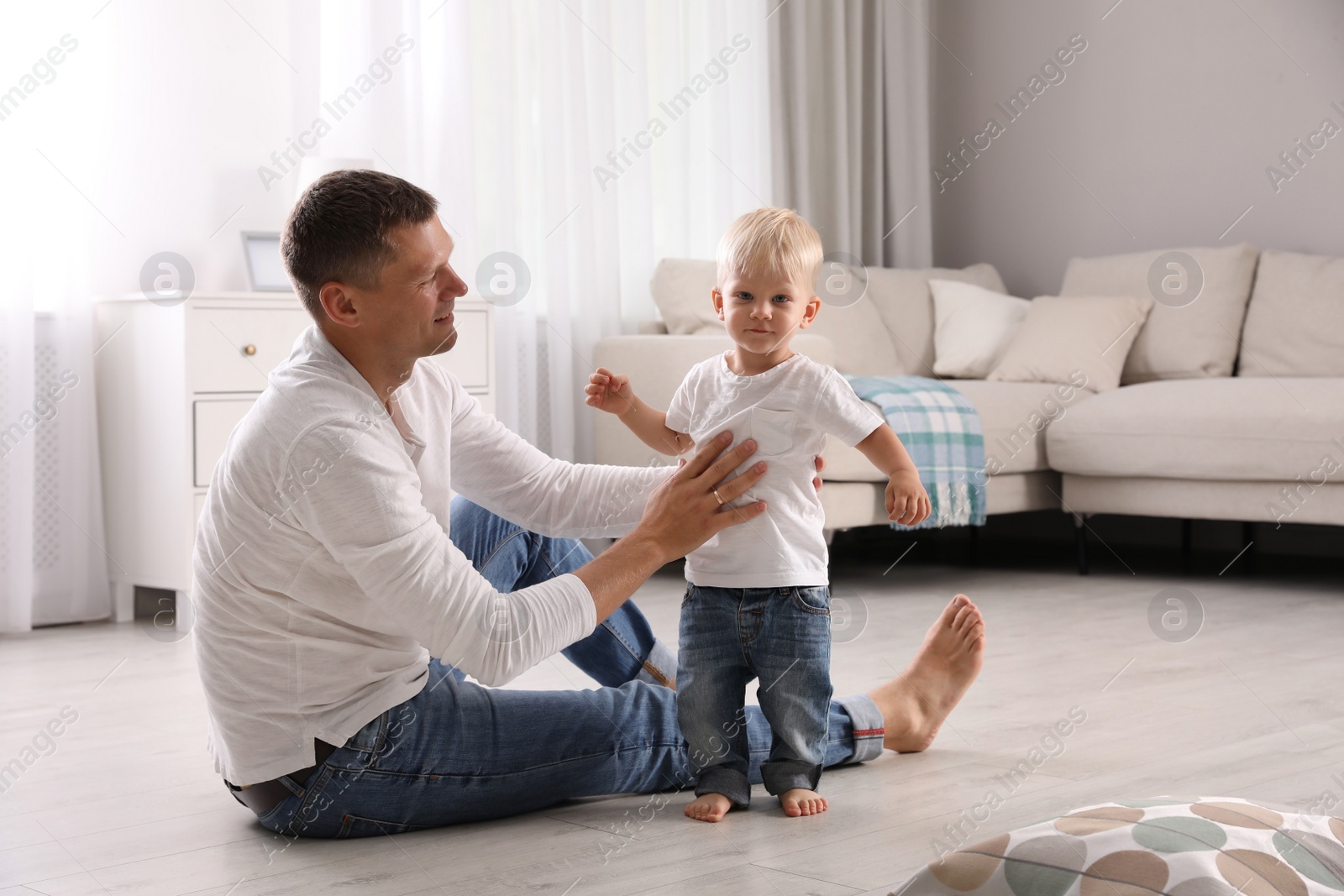 Photo of Father with his cute little son in living room