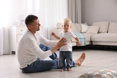 Father with his cute little son in living room