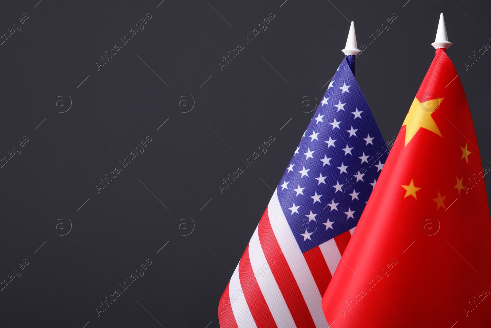 Photo of Closeup view of USA and China flags on dark background, space for text. International relations