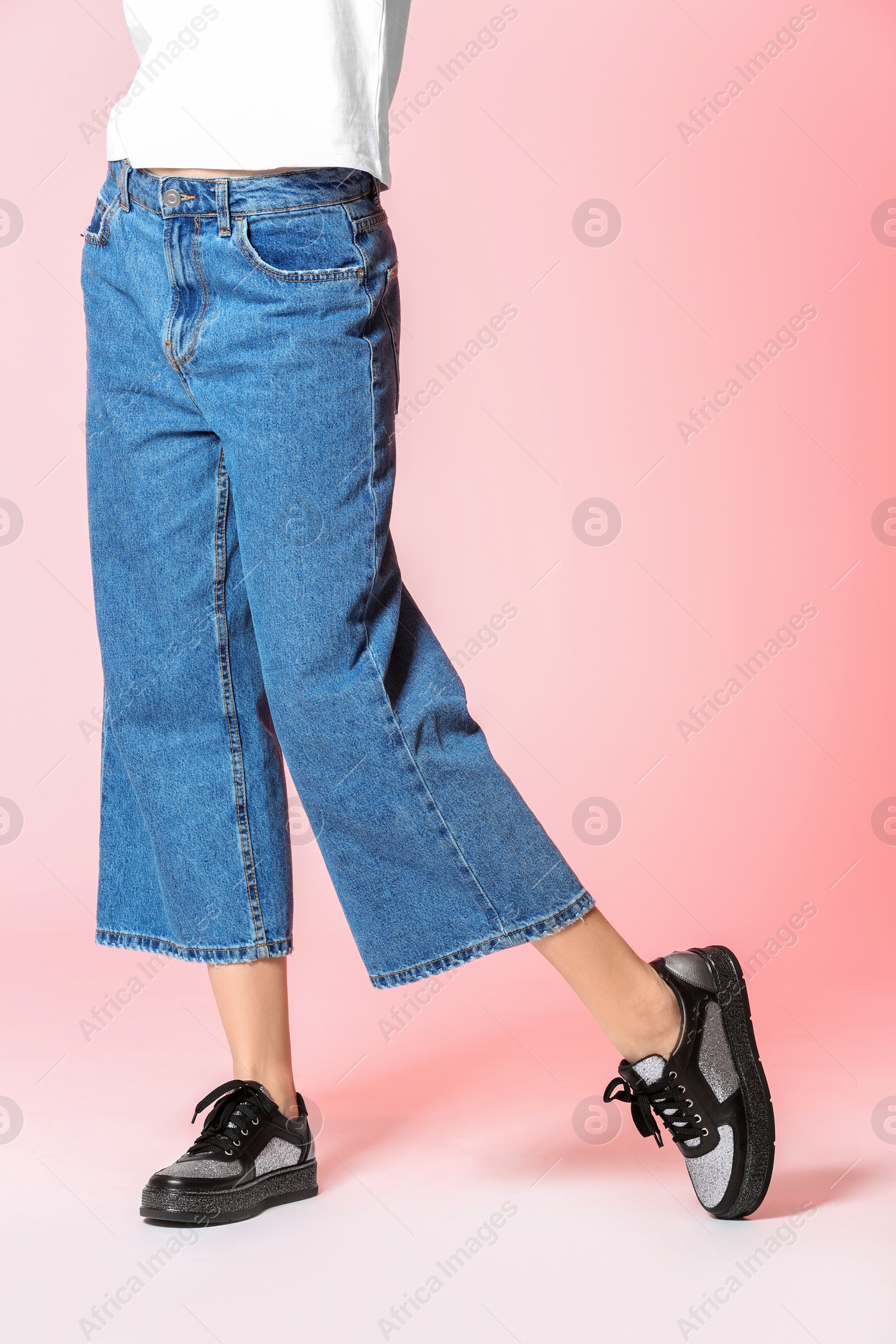Photo of Fashionable woman in stylish shoes on color background