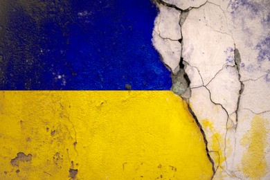 National flag of Ukraine painted on old cracked wall