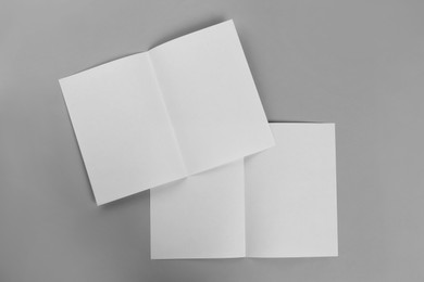 Blank paper brochures on light grey background, flat lay. Mockup for design