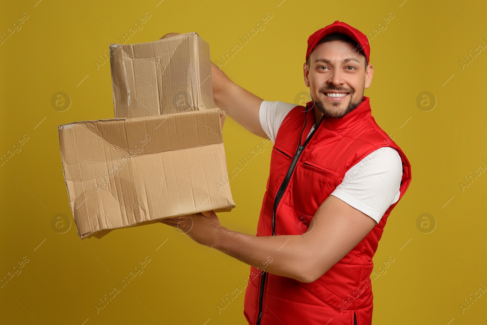 Photo of Courier with damaged cardboard boxes on yellow background. Poor quality delivery service