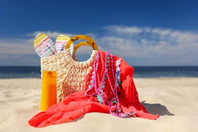 Photo of Stylish beach accessories for summer vacation on sand near sea
