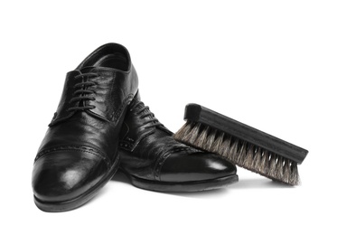 Photo of Stylish men's shoes and cleaning brush on white background