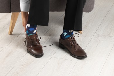 Man wearing stylish shoes and colorful socks indoors, closeup
