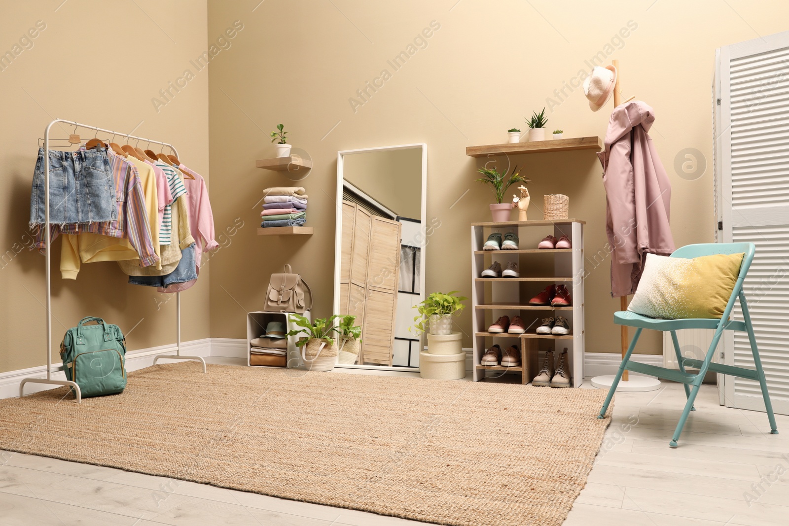 Photo of Stylish dressing room interior with trendy clothes and shoes