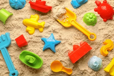 Photo of Beach toy kit on sand, flat lay. Outdoor play