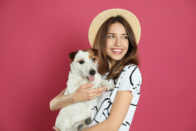 Photo of Young woman with her cute Jack Russell Terrier on pink background. Lovely pet