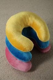 Photo of Many colorful travel pillows on beige rug