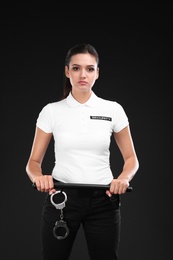 Female security guard with police baton on dark background