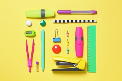 Flat lay composition with different school stationery on yellow background