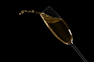 Glass of fizzy champagne on black background, closeup. Space for text