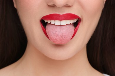Photo of Woman with red lipstick showing her tongue, closeup