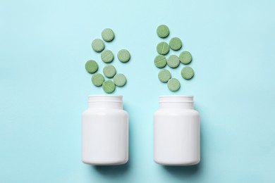 Photo of Bottles with pills on turquoise background, flat lay. Prebiotic supplements