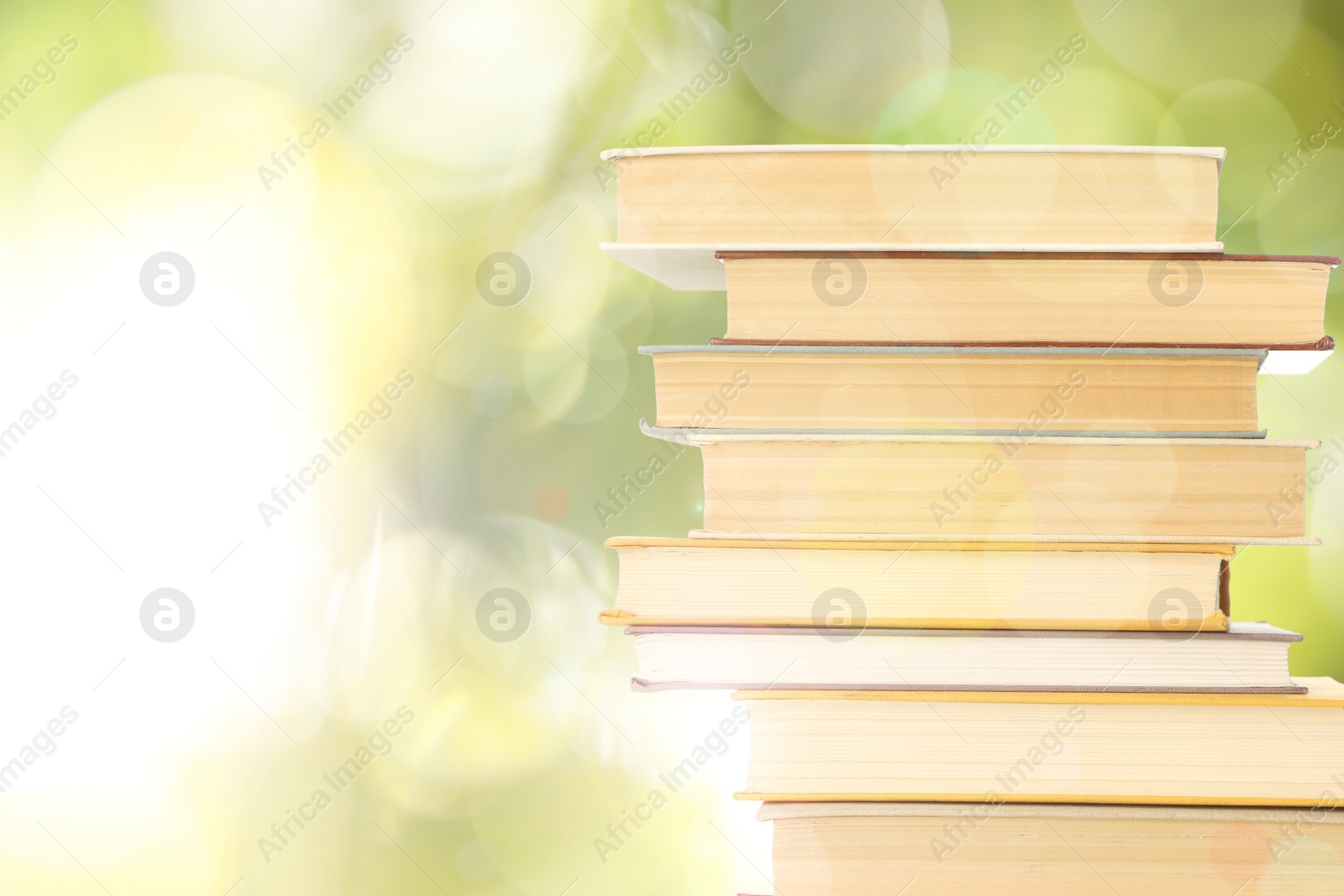 Image of Stack of books on blurred background, space for text. Bokeh effect 